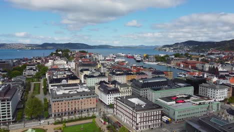 Hermosa-Ciudad-Aérea-De-Bergen-Desde-El-Parque-Festplassen-Y-Viendo-Bryggen-Con-El-Paseo-Marítimo-Y-La-Isla-Askoy-En-El-Fondo---Antena-En-Movimiento-Hacia-Adelante