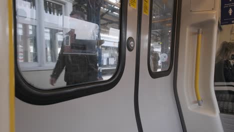 London-underground-District-line-train-pulling-into-Turnham-green-railway-station-from-inside