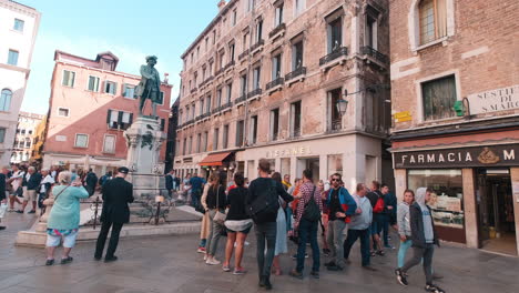 Tiro-Panorámico-En-Cámara-Lenta-De-Turistas-Tomando-Fotos-De-La-Estatua-Italiana-De-Daniele-Manin-En-El-Centro-De-Venecia,-Italia