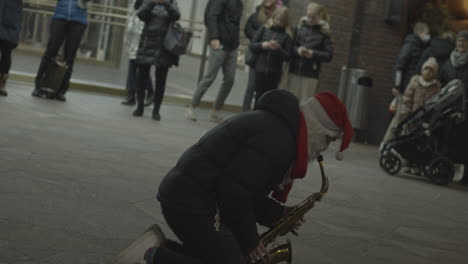 Straßenmusiker,-Gekleidet-Wie-Der-Weihnachtsmann,-Spielen-Auf-Saxophon