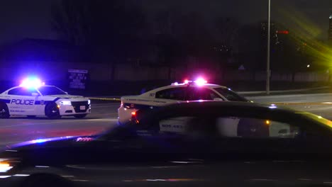 Mississauga-Police-vehicles-flashing-emergency-lights-in-night-barricade-closing-street-during-accident-Canada