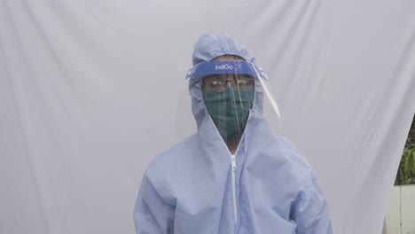 Doctor-in-PPE-kit-blue-protective-suit,-surgical-mask-latex-gloves