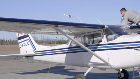 Airport-Crew-Refueling-Cessna-Plane-On-A-Sunny-Day-With-Airplane-Landing-In-Background