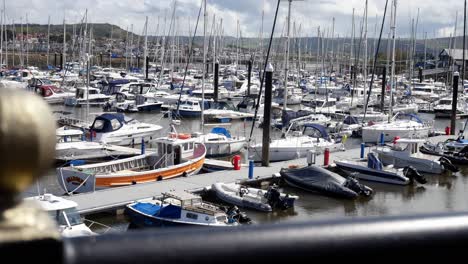 Overlooking-railing-to-luxury-yachting-marina-boats-in-colourful-touristic-holiday-harbour-dolly-right