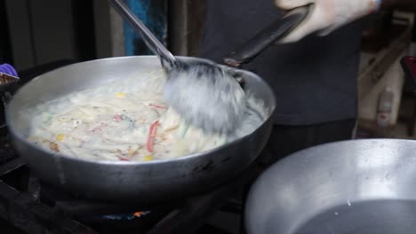 Chef-Profesional-Prepara-Pasta-Con-Salsa-Blanca-En-Una-Tienda-De-Comida-Callejera-En-Chat-Gali-En-Agra,-India,-El-7-De-Marzo-De-2021