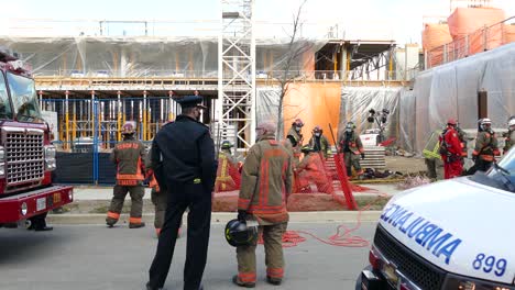 Policías-Y-Bomberos-Investigando-En-Un-Sitio-De-Construcción-Industrial,-Tiro-Estático