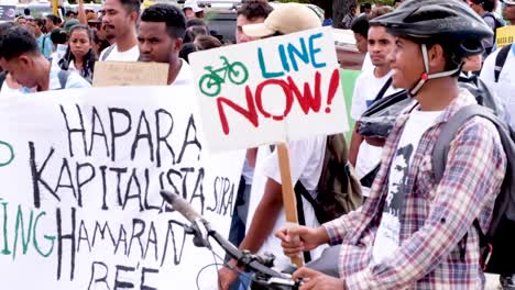 People-gathering,-marching-and-holding-bike-line-lane-now-sign