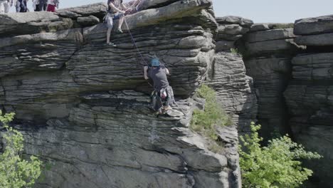 Tourist-Climbing-Up-The-Overhang-Gritstone-Rock-Of-Bamford-Edge-In-Hope-Valley,-Derbyshire,-England