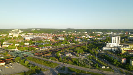 Aerial-view-of-passing-train,-driving-cars-and-beautiful-cityscape-of-Gdansk-in-summer