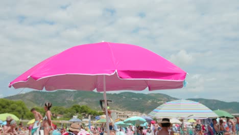 Cerca-De-Una-Sombrilla-De-Playa-Rosa-En-La-Costa-Del-Mar-Bajo-El-Sol-En-Verano