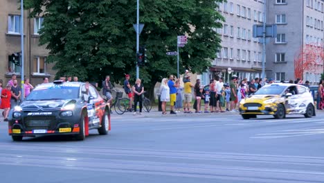 Inicio-Festivo-Del-Trofeo-De-Rally-Europeo-Fia-2021-Y-Desfile-De-Autos-En-Las-Calles-De-Liepaja,-Autos-De-Rally-Que-Pasan-A-Los-Espectadores,-Tiro-De-Seguimiento-De-ángulo-Medio