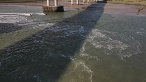 Gente-Montando-Motos-Acuáticas-Bajo-El-Puente-Kingsferry-Y-El-Cruce-Sheppey-En-El-Reino-Unido---Toma-Panorámica