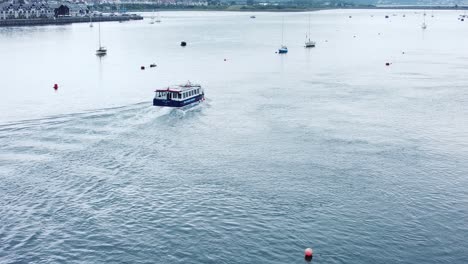 Aerial-view-sightseeing-boat-attraction-travelling-down-Conwy-river-alongside-seaside-town-North-Wales