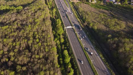 Busy-highway-surrounded-by-vegetation-at-sunset