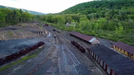 An-Aerial-View-of-an-Abandoned-Narrow-Gauge-Coal-Rail-Road-with-Rusting-Hoppers-and-Freight-Cars-and-Support-Building-Starting-to-be-Restored