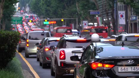 Línea-De-Autos-Detenidos-En-El-Atasco-De-Tráfico-Del-Distrito-De-Gangnam,-Concurrido-Tráfico-De-Calles-En-La-Puesta-De-Sol-De-Seúl-Corea-Del-Sur---Editorial-2021,-28-De-Julio,-Banderas-Coreanas-A-Lo-Largo-De-La-Carretera