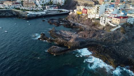 Erstaunliche-Aussicht-Meer-Küste-Insel-Stadt-Gebäude-Spanien-Teneriffa-Drohne-Geschossen-4k-Blaues-Meer-Knallt-In-Felsen-Berge-Im-Hintergrund