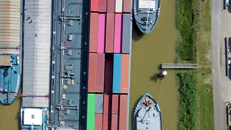 Top-down-aerial-of-sea-containers-on-board-of-docked-cargo-ship---close