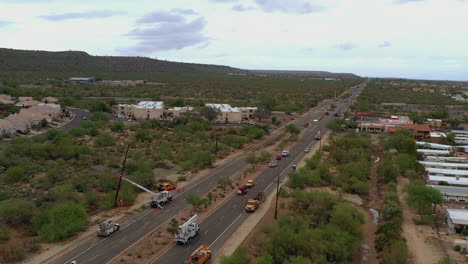 Aerial-circling-over-city-crew-repairing-steel-pylon-after-storm,-Arizona