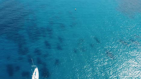 Top-down-view-of-yacht-bobbing-near-the-French-coast
