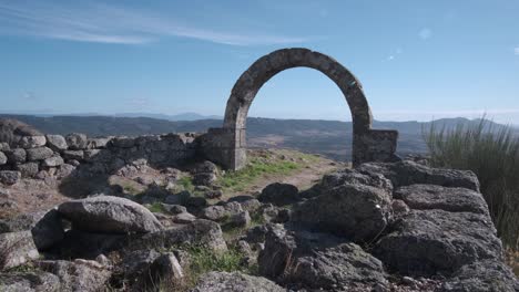 Arched-architectural-detail-in-Monsanto-village-and-panorama-in-background,-Portugal
