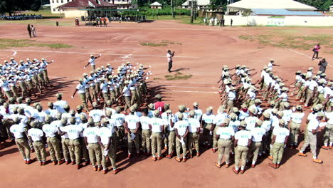 Civil-service-youth-at-the-NYSC-camp-march-in-formation-in-a-parade---aerial-view-ascending-tilt-down