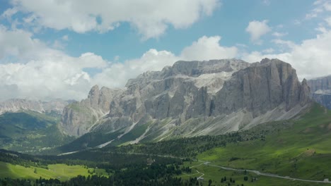Aerial-Panorama,-mountain-tops-surrounded-by-green-meadows,-Dolomites