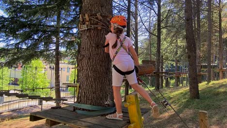 Little-child-girl-with-harness-having-fun-at-adventure-park