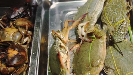 Sea-crabs-and-land-crabs-displayed-for-grilling-at-a-street-food-stall-in-the-night-market-of-Mondulkiri,-Cambodia