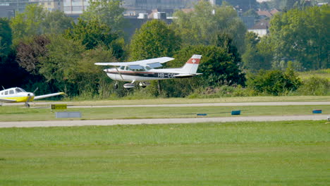 Tracking-shot-of-swiss-light-aircraft-landing-at-airport-between-alp-mountains-in-Switzerland