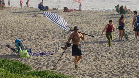Caucasian-man-using-a-metal-detector-on-a-beach