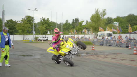 Der-Stunt-Fahrer-Zeigt-Mit-Dem-Daumen-Nach-Oben,-Während-Er-Auf-Einem-Quad-Einen-Side-Wheelie-Trick-Ausführt