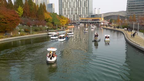 Parque-Central-De-Incheon-Songdo---La-Gente-Monta-Botes-De-Remos-En-El-Lago-Y-Camina-En-El-Colorido-Otoño,-Corea-Del-Sur