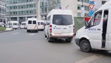 Furgonetas-De-La-Policía-Belga-Que-Protegen-La-Rotonda-De-Shuman-Durante-Los-Disturbios-Contra-La-Corona-En-La-Ciudad-De-Bruselas,-Bélgica---El-Oficial-De-Policía-Entra-En-El-Vehículo