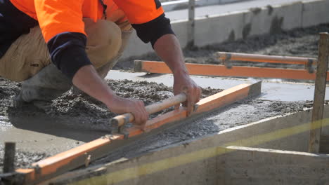 Trabajador-De-La-Construcción-Nivelando-Cemento-Húmedo-Con-Paleta-En-El-Sitio-De-Vertido-De-Losa