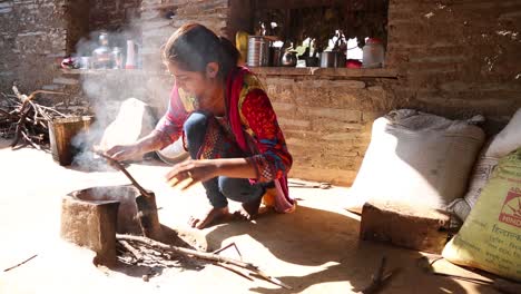 Auténtica-Escena-De-La-Vida-Rural-Real-De-La-Pobre-Mujer-India-Dalit-Enciende-Fuego-Para-Cocinar-Al-Aire-Libre-Soplando-Sobre-Palos-De-Madera