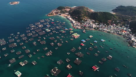 Aerial,-floating-fish-farms-on-tropical-ocean-island-coast-in-Southeast-Asia