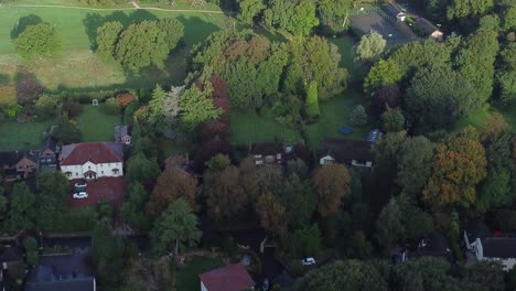 High-end-wealthy-Cheshire-real-estate-property-in-secluded-lush-green-trees-aerial-tilt-up-view