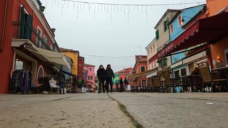 Low-Angle-Ground-Surface-First-Person-Pov-Von-Menschen,-Die-In-Der-Innenstadt-Von-Burano-Und-In-Bunten-Häusern-Spazieren-Gehen