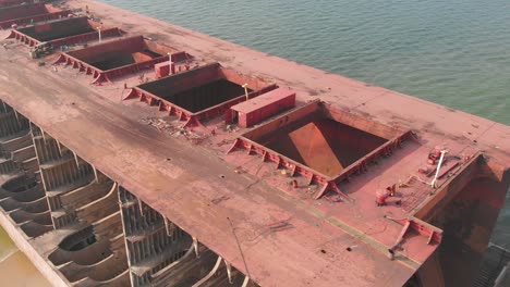 Aerial-Dolly-Back-Over-Large-Dismantled-Ship-With-Open-Hatches-At-Gadani,-Pakistan