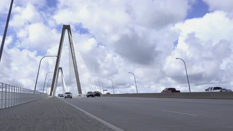 Street-level-view-of-the-bridge-with-arches-in-the-background-against-clouds-and-blue-sky