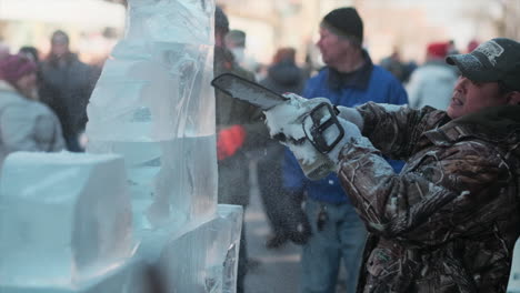 Chainsaw-artist-carving-ice-sculpture-for-outdoor-winter-festival-audience