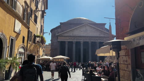 Dolly-forward-shot-of-many-tourist-walking-on-square-of-The-Pantheon-in-Rome-during-hot-summer-day