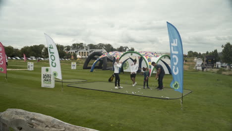 Golfsport-Event-Assistenten-Zeigen-Kindern,-Wie-Man-Auf-Dem-Trainingsplatz-Spielt