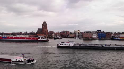 Luftflug-über-Die-Oude-Maas,-Während-Drei-Schiffe-Mit-Unserer-Dame-Von-Dordrecht-Im-Hintergrund-Aneinander-Vorbeifahren