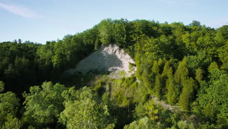 Hilly-forest-landscape-with-sandy-eroded-cliff-valley-and-dense-green-tree-canopy