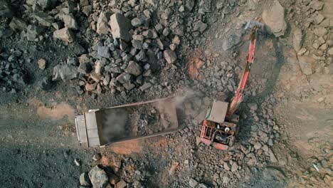 Toma-Aérea-De-Un-Dron-De-Una-Excavadora-Cargando-Rocas-En-Un-Camión