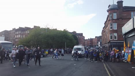 Ein-Weißer-Lieferwagen,-Der-Langsam-Fährt,-Weil-Fußballfans-Die-Straße-überqueren