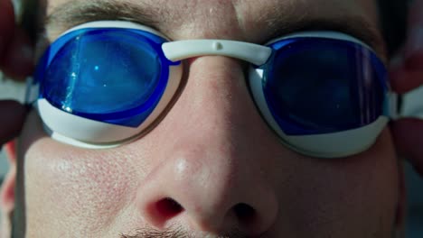 Male-caucasian-swimmer-putting-on-the-swimming-glasses