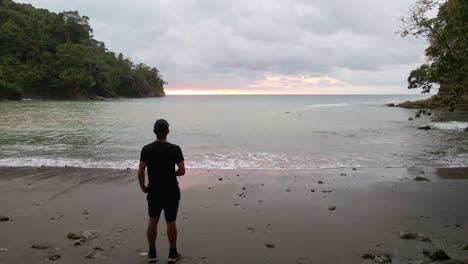 Un-Hombre-Mirando-El-Océano-Al-Atardecer-En-La-Playa-De-Playa-La-Vaca-En-Costa-Rica-En-Un-Día-Nublado